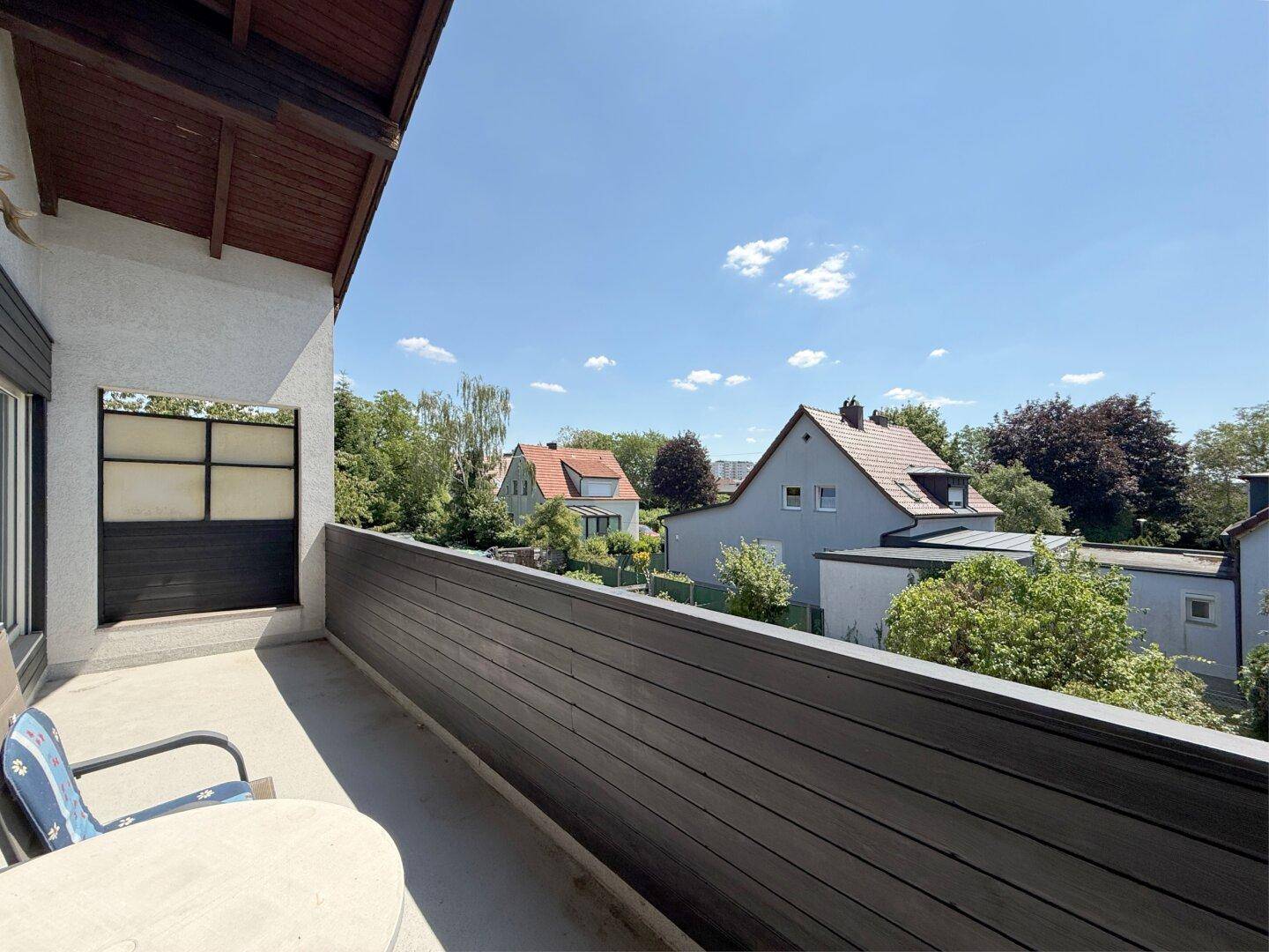 Geräumiger Balkon mit Sitzgelegenheiten und Blick auf die Nachbarschaft.