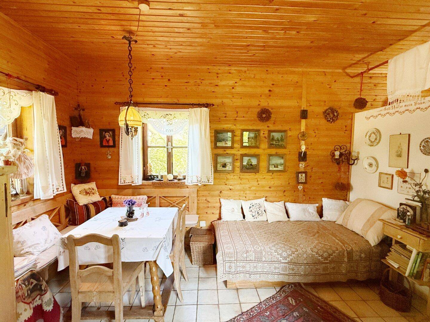 Rustikaler Wohn-Essbereich mit Holztäfelung, Fliesenboden und traditionellen Möbeln im Landhausstil.