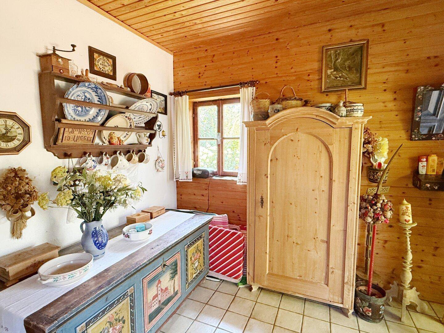 Traditionell eingerichteter Raum mit Holztäfelung, Fliesenboden und einem rustikalen Holzschrank.