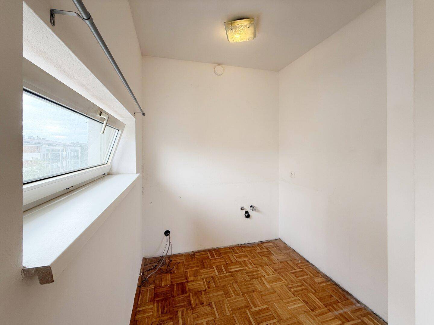 Kleiner Raum mit Fenster und Wasseranschlüssen, ideal als Abstellraum.
