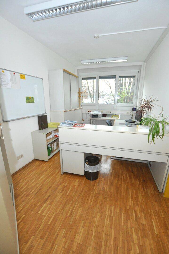 Helles Einzelbüro mit Schreibtisch, Stauraum und einem Fenster mit Blick nach draußen.