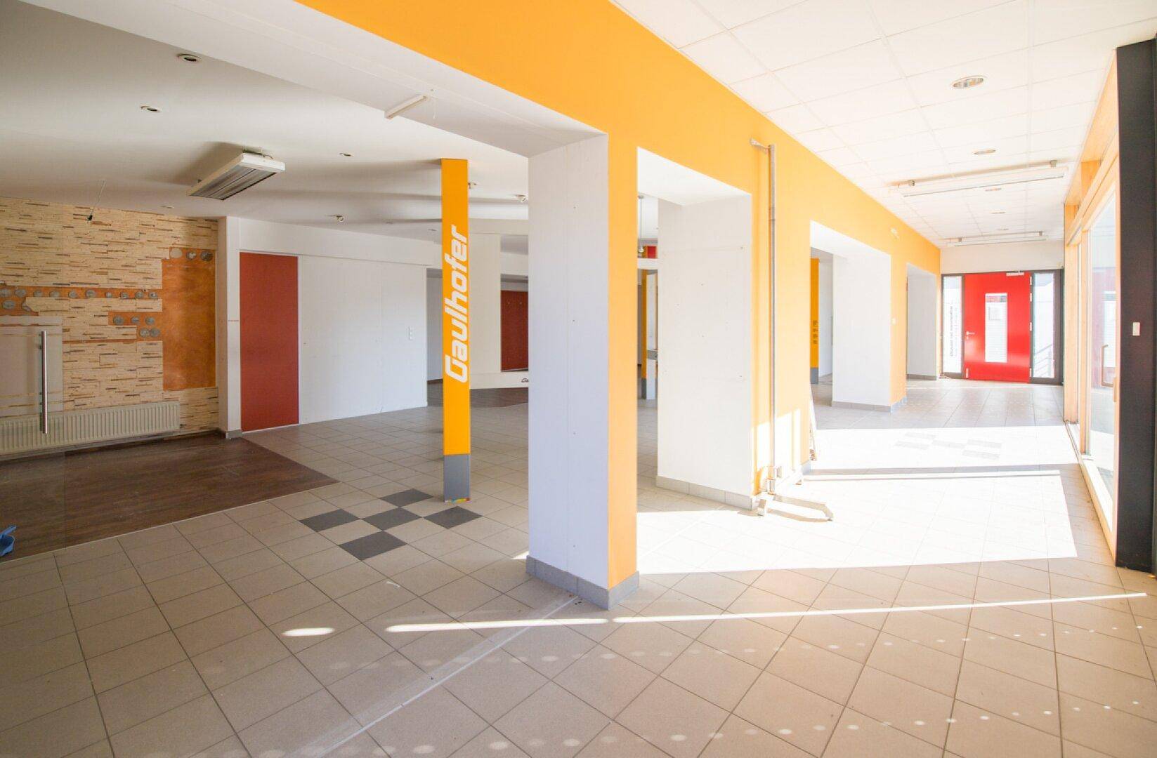 Geräumiger Verkaufsraum mit Fliesenboden und viel Tageslicht, ideal für verschiedene Geschäftskonzepte.