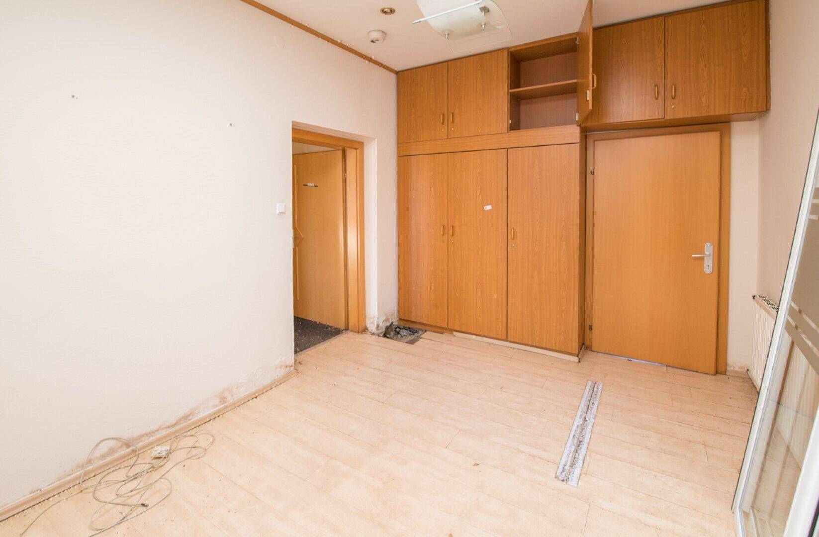 Büro mit Laminatboden und Einbauschränken, bietet praktischen Stauraum und Funktionalität.