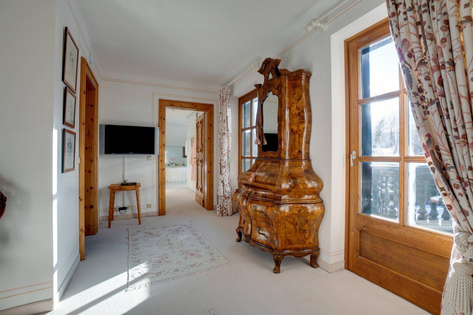 Schlafzimmer mit elegantem Schrank, Teppichboden und Zugang zum Balkon, der frische Luft und Ausblick bietet.