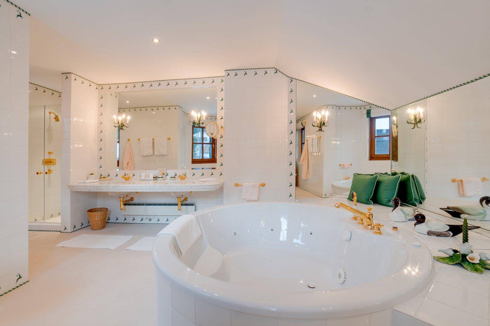 Geräumiges Badezimmer mit großem Whirlpool, Doppelwaschbecken und eleganten Armaturen, die Komfort bieten.