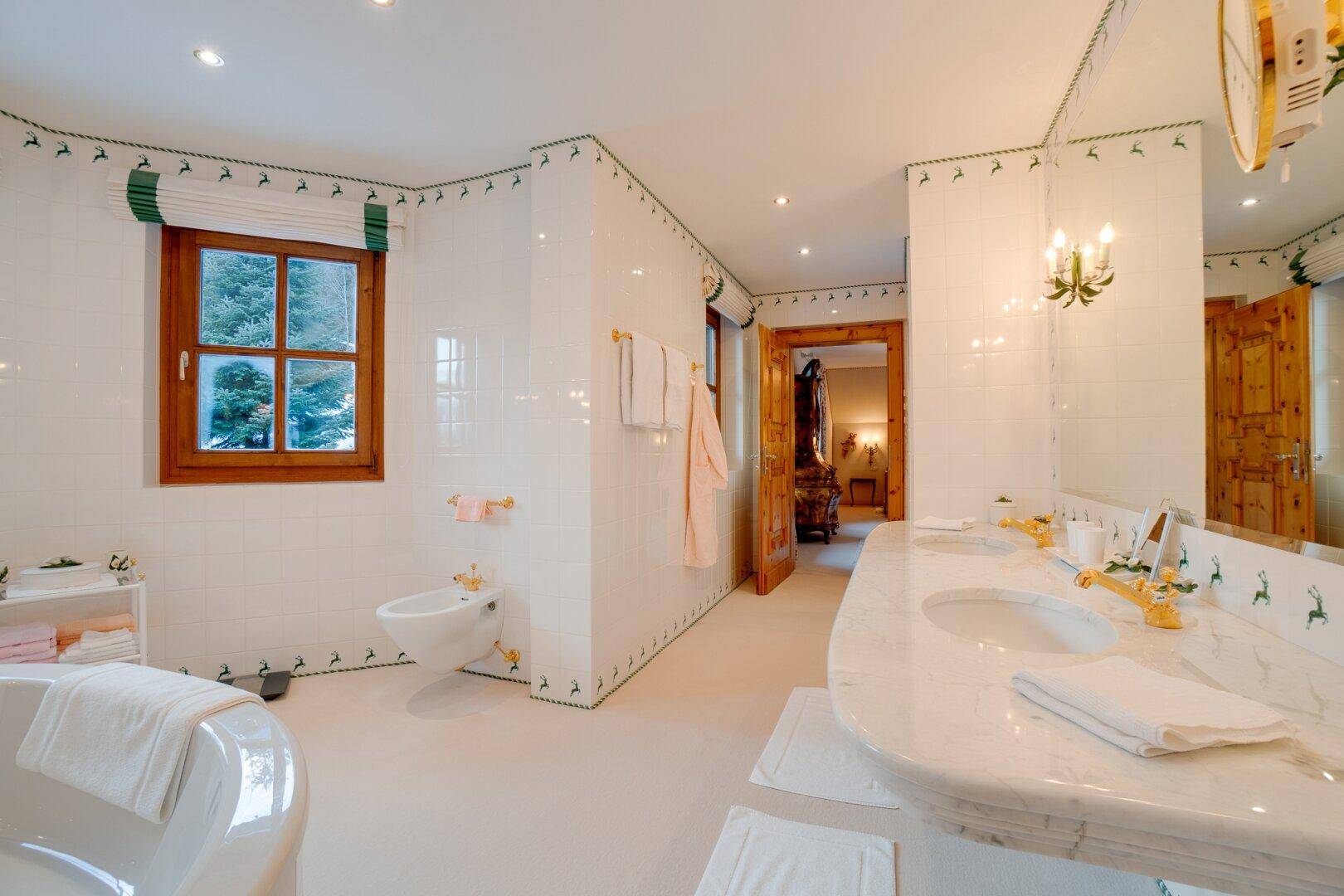 Helles Badezimmer mit Bidet, Fenster und Marmorwaschtisch, das Funktionalität und Stil vereint.