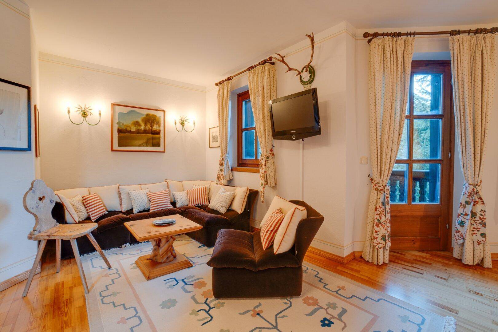 Komfortables Schlafzimmer mit Sitzgelegenheit, Holzboden und traditioneller Einrichtung, die zum Entspannen einlädt.