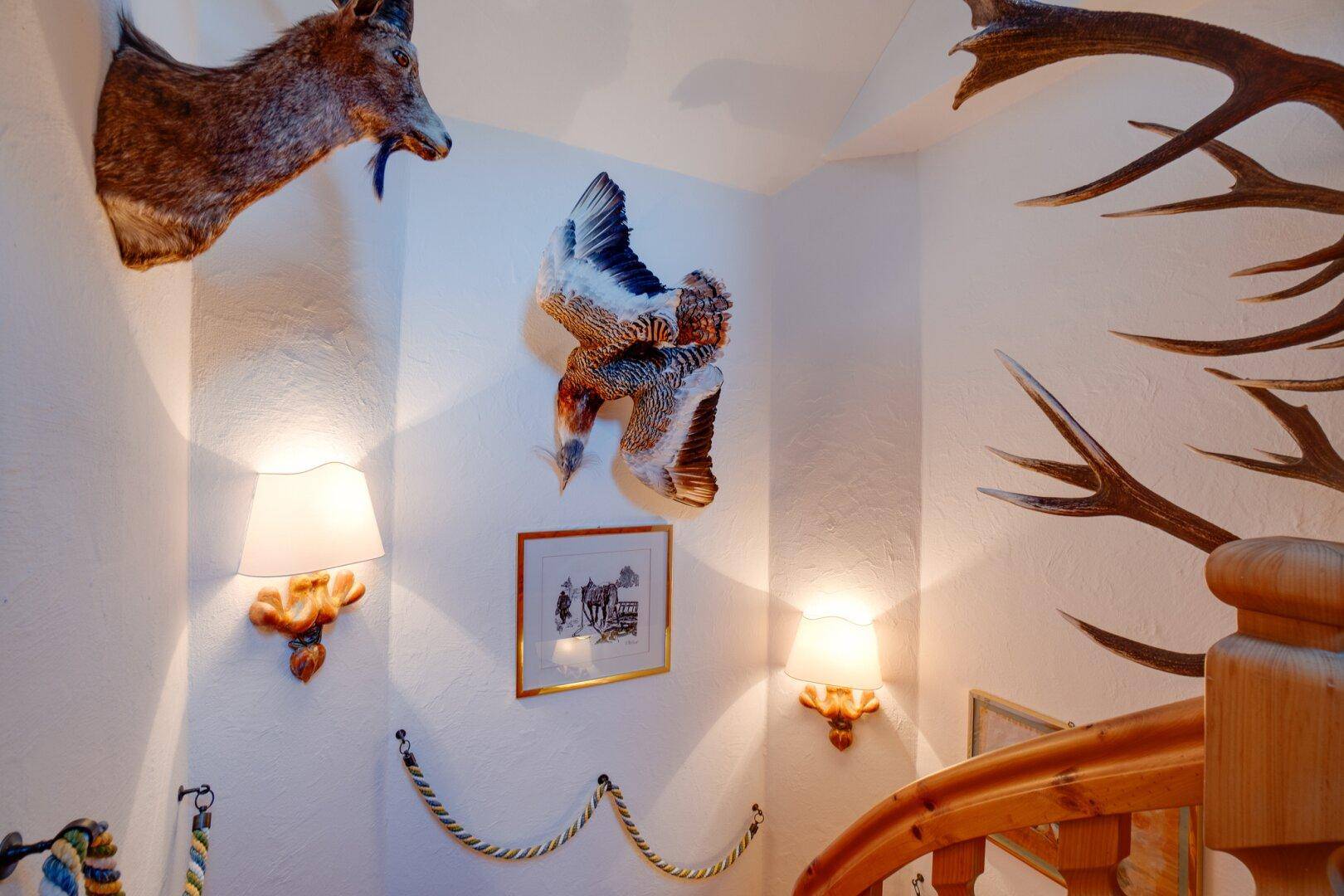 Heller Dachgeschoss-Wohnbereich mit Holzboden, Dachschrägen und traditionellen Möbeln, die eine warme Atmosphäre schaffen.