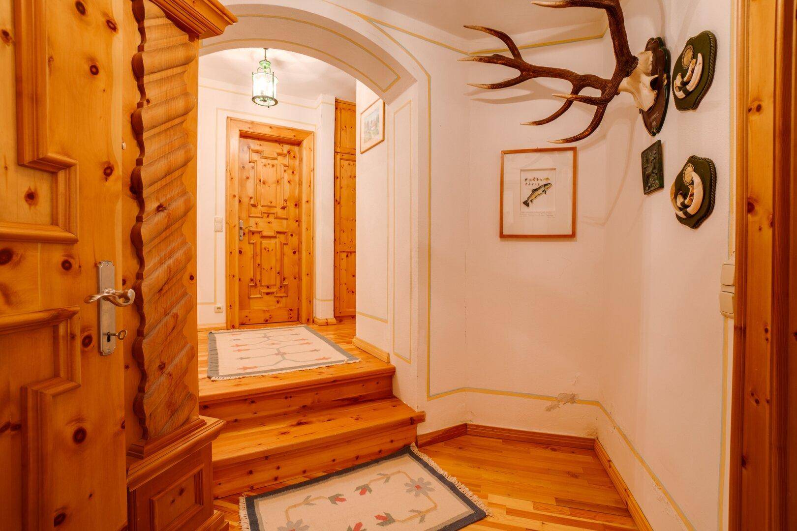 Entspannungsbereich mit Sitzgelegenheiten, Fliesenboden und Zugang zur Sauna, ideal zum Relaxen.