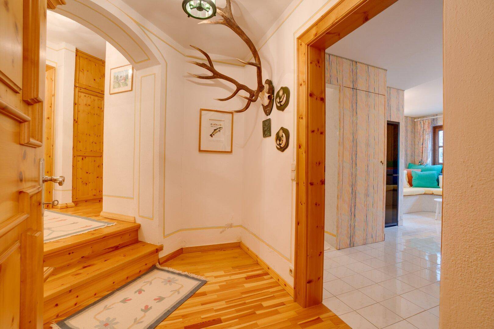 Eingang zur Sauna im Wellnessbereich mit Sitzgelegenheiten und bunten Kissen, die zum Verweilen einladen.