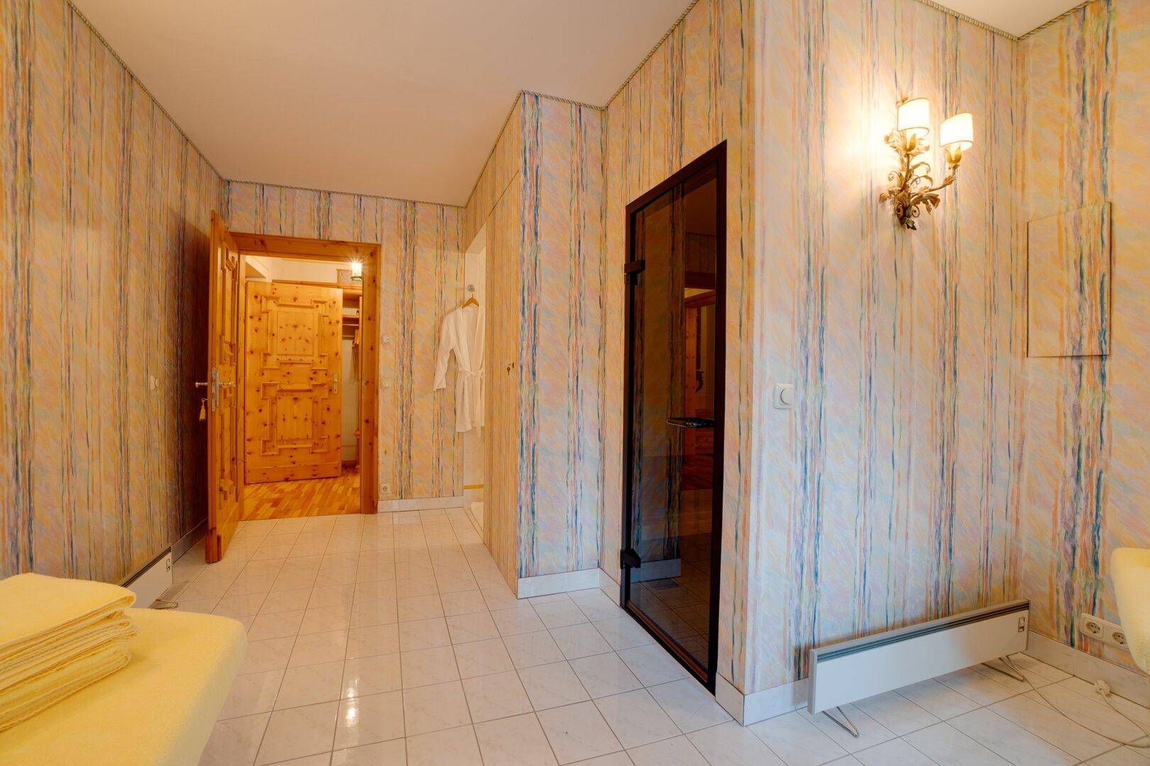 Separates WC im Wellnessbereich mit Waschbecken, Spiegel und weißen Fliesen, die Sauberkeit ausstrahlen.