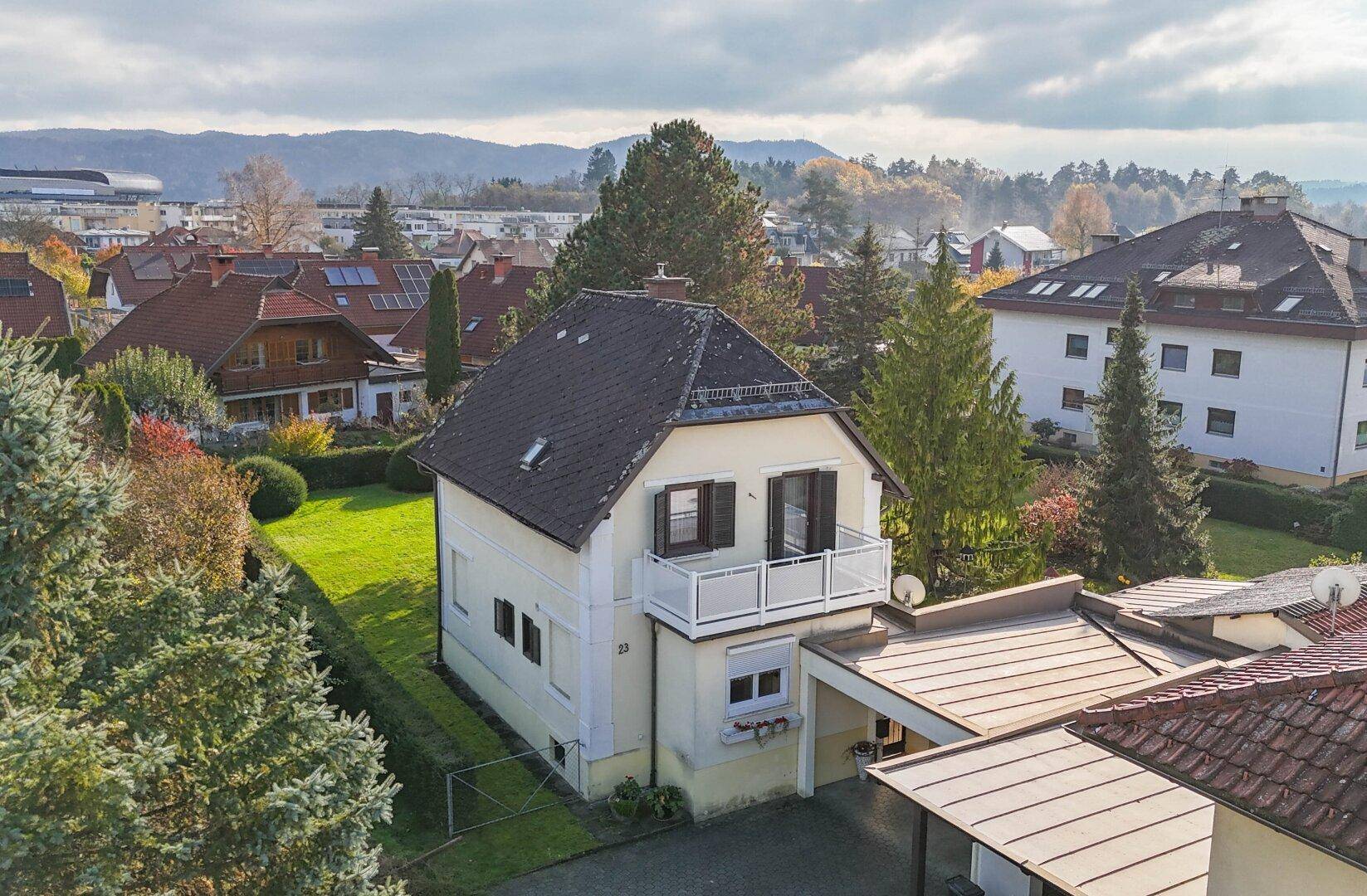 Luftaufnahme des Hauses mit Balkon, Carport und Blick auf die umliegende Nachbarschaft.