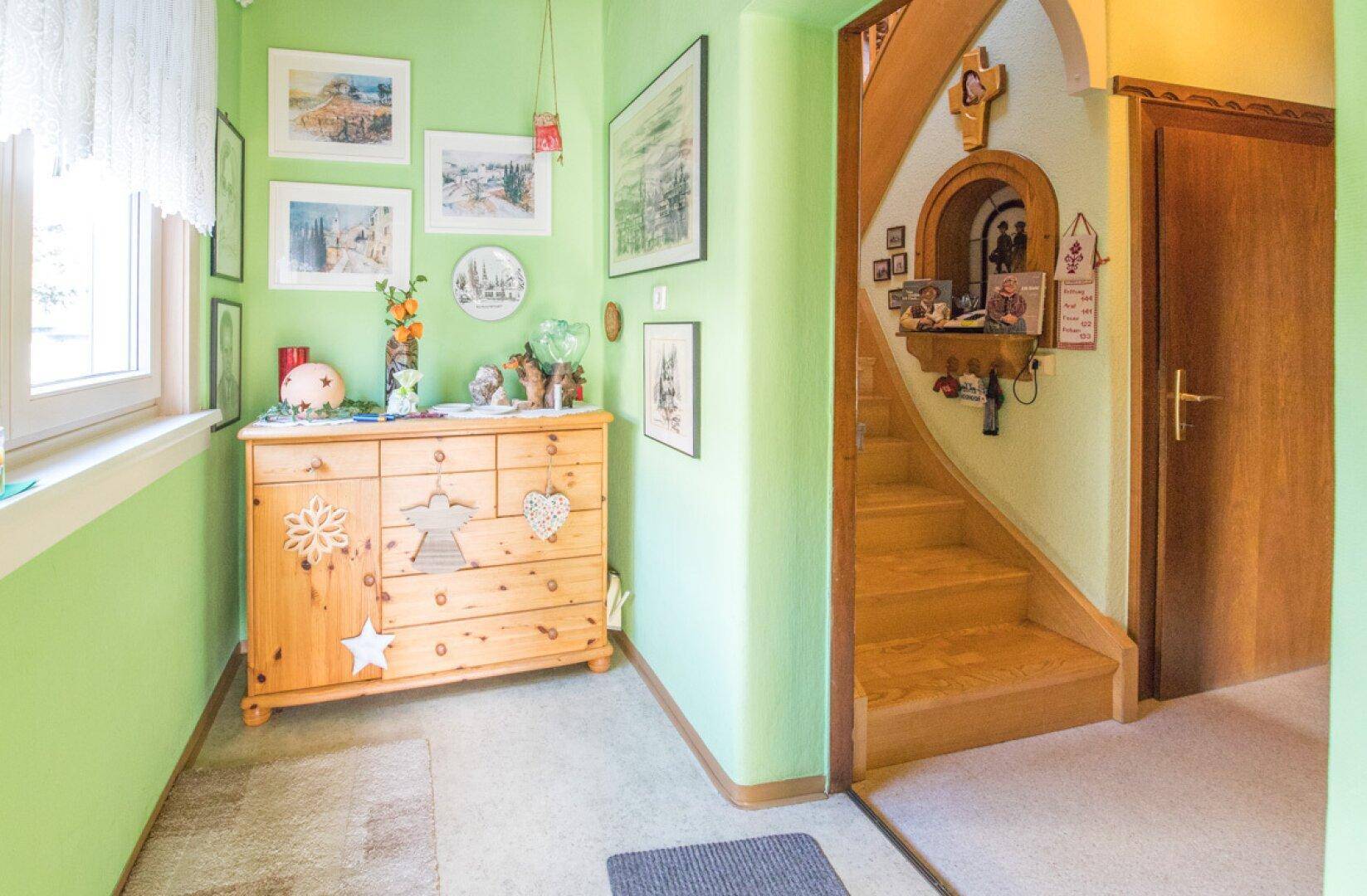 Traditioneller Flur mit Holztreppe, Holztüren und Deckenverkleidung.