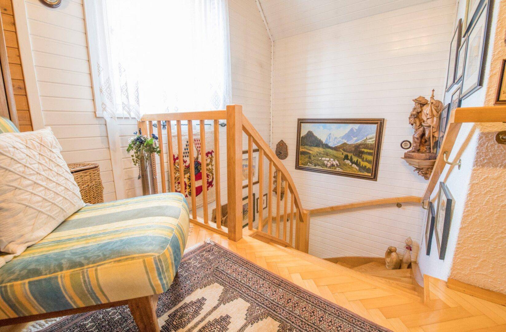 Flur mit Einbauschränken aus Holz, Parkettboden und Zugang zu den Schlafzimmern.