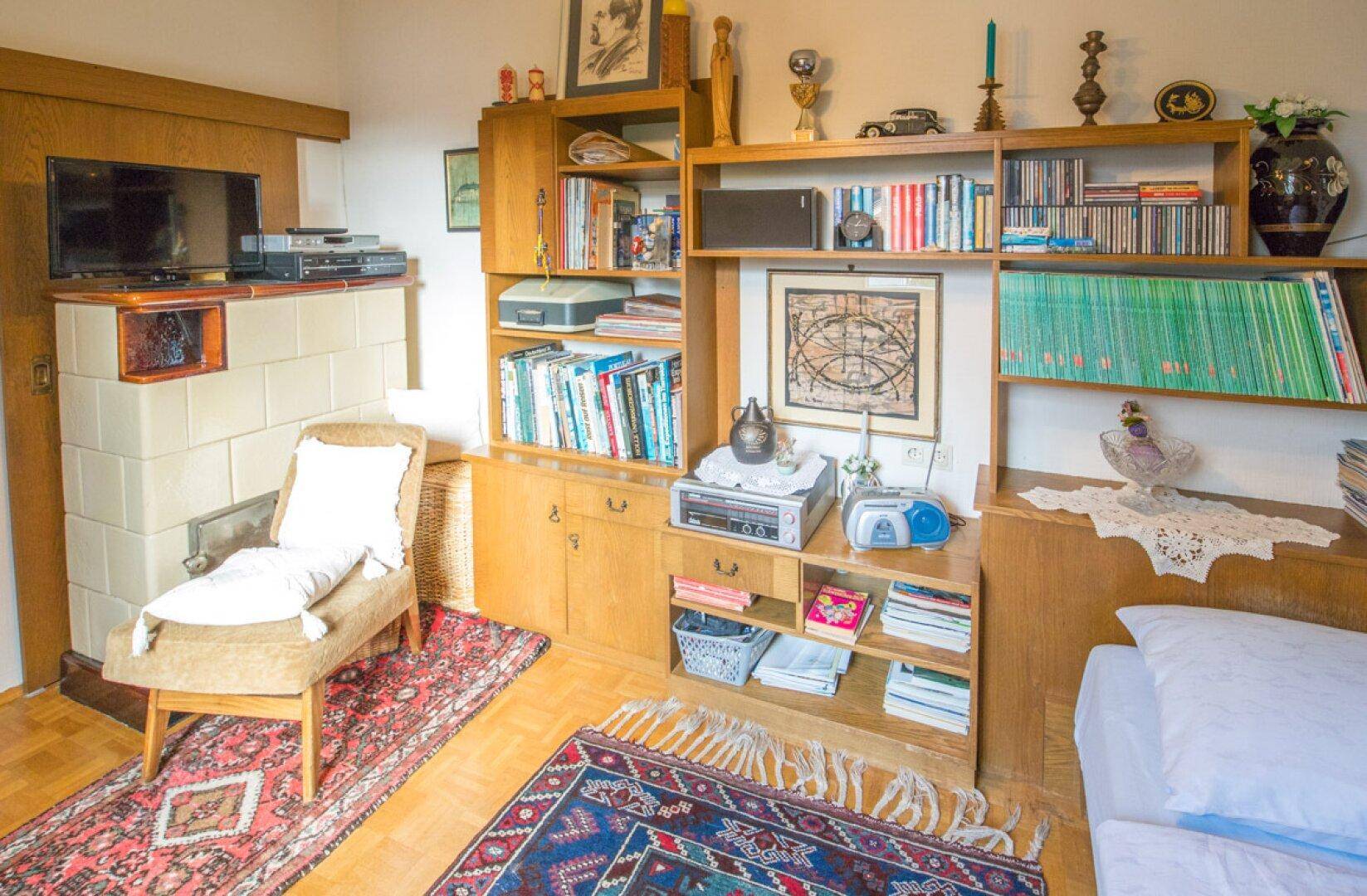 Geräumige Garage mit Fliesenboden, Fenster und Stauraum für verschiedene Gegenstände.