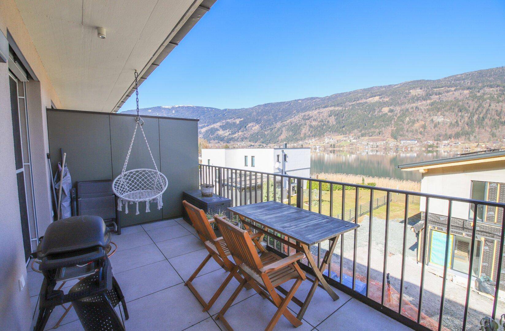 Geräumiger Balkon mit Seeblick, Grill und Sitzgelegenheiten für entspannte Stunden.