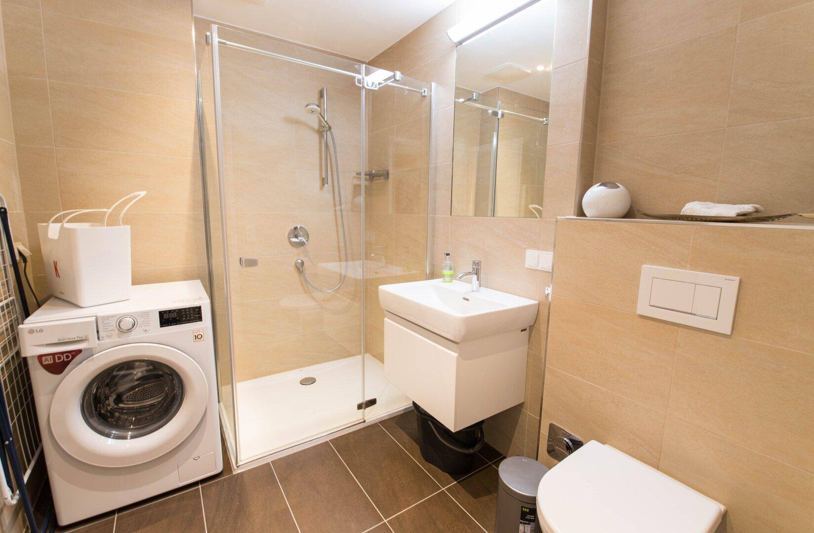 Modernes Badezimmer mit ebenerdiger Dusche, Waschbecken und WC.