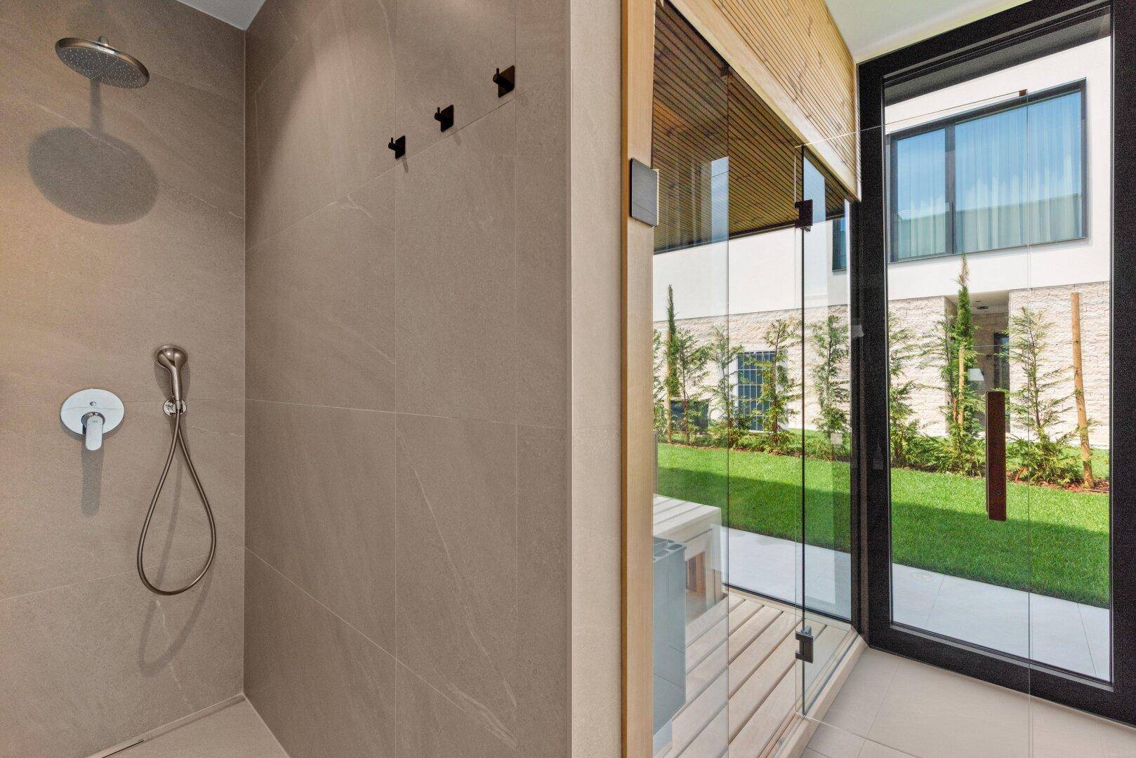 Modernes Badezimmer mit begehbarer Dusche und direktem Zugang zu einer privaten Sauna.