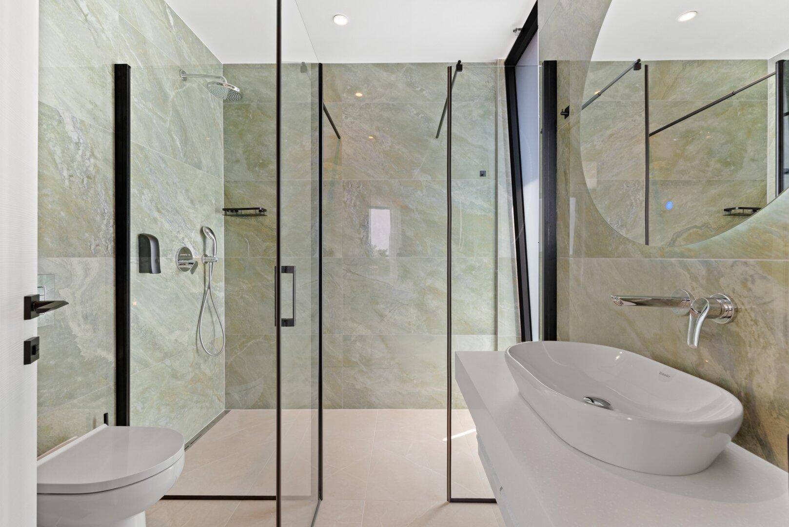 Modernes Badezimmer mit begehbarer Dusche, Waschbecken und wandhängendem WC.