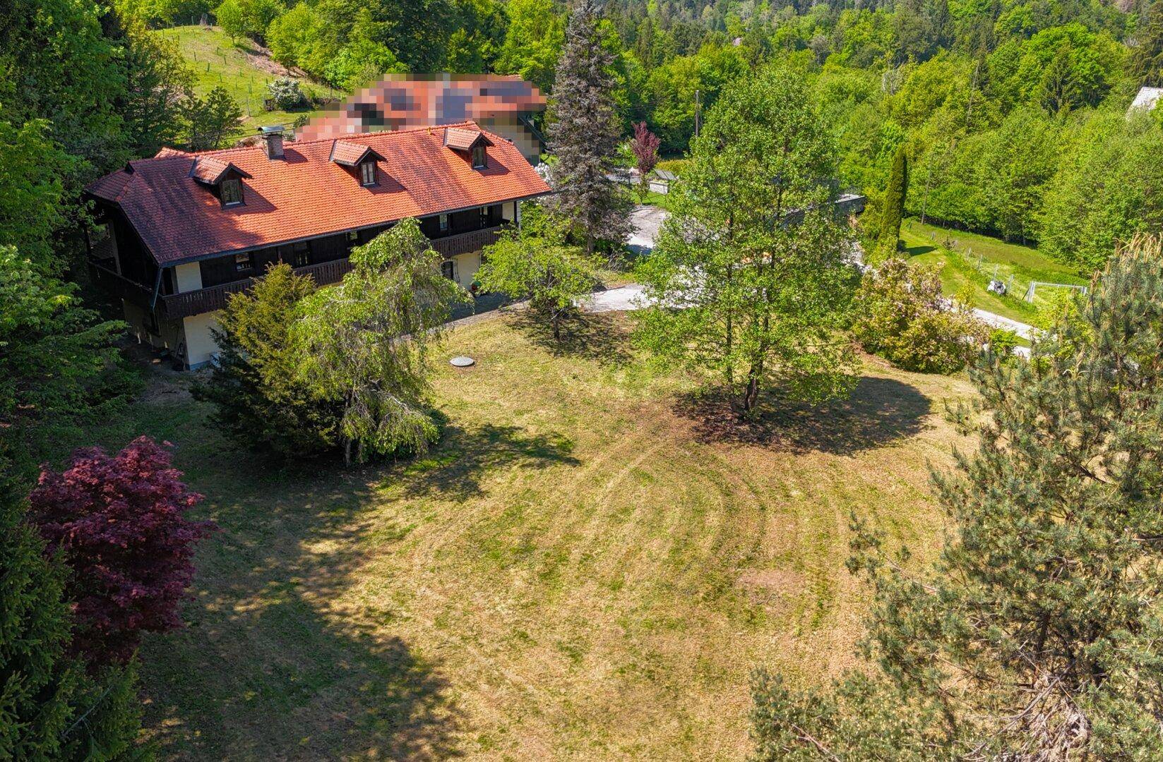 Weitläufige Luftaufnahme des Anwesens mit großem Garten und Blick auf die Umgebung.