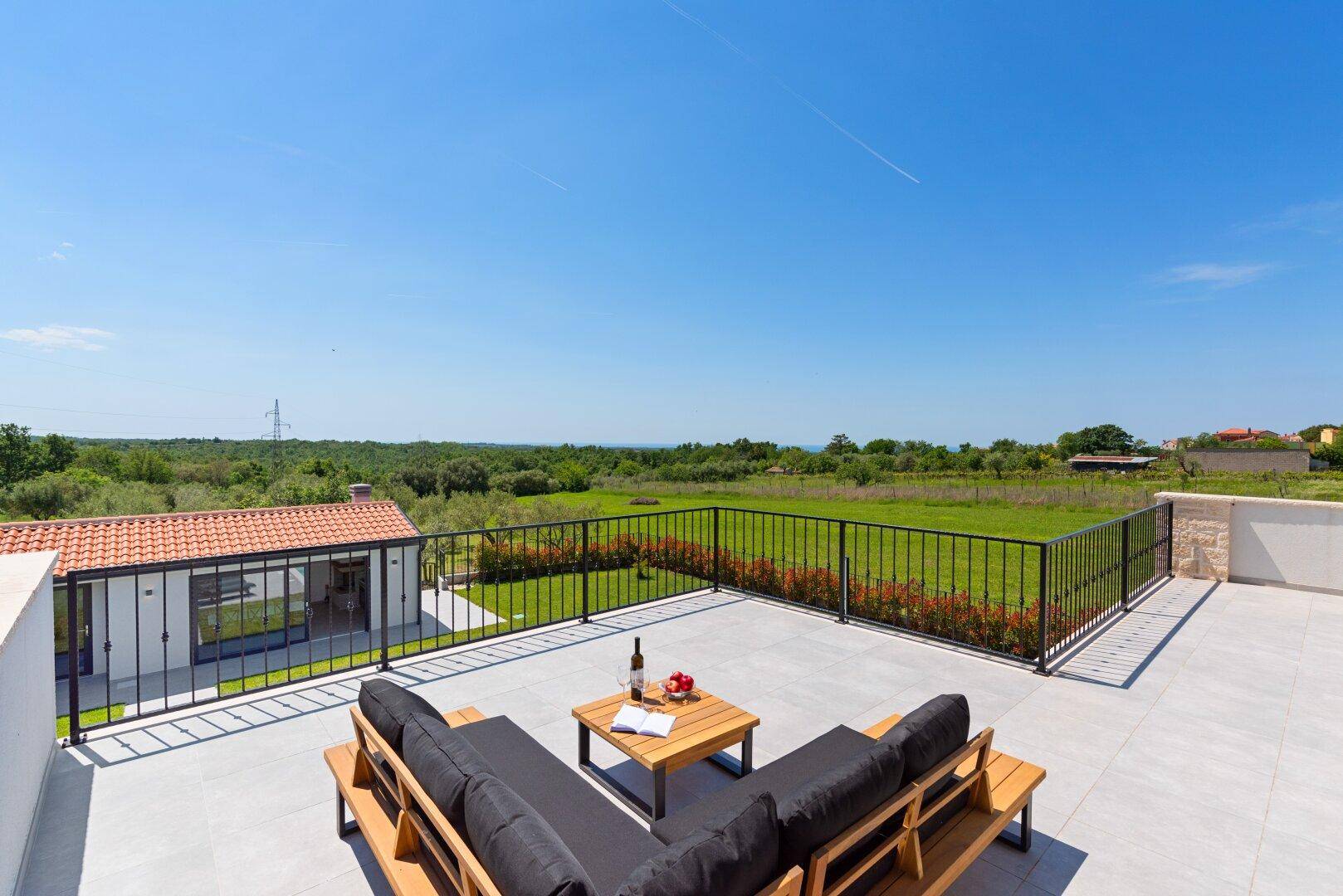 Helle Dachterrasse mit bequemen Lounge-Möbeln, ideal für entspannte Stunden im Freien.