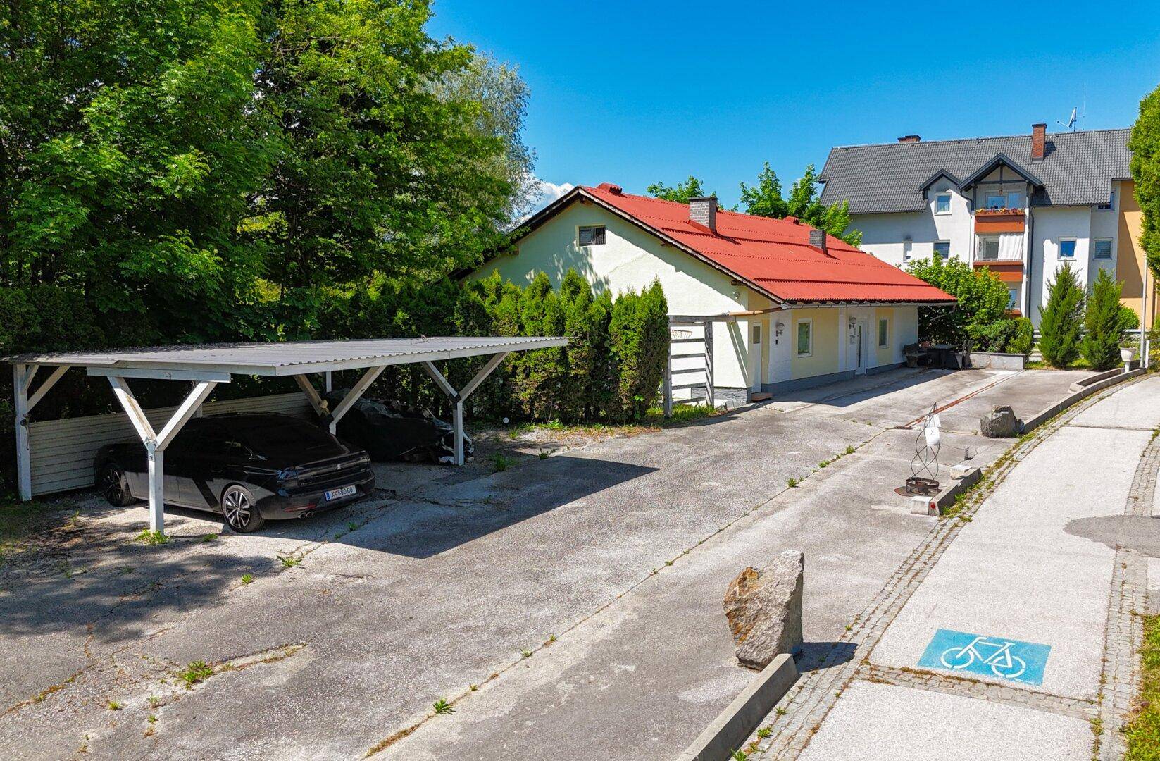 Detailansicht des Carports und der Zufahrt zum Haus mit gepflegter Umgebung.