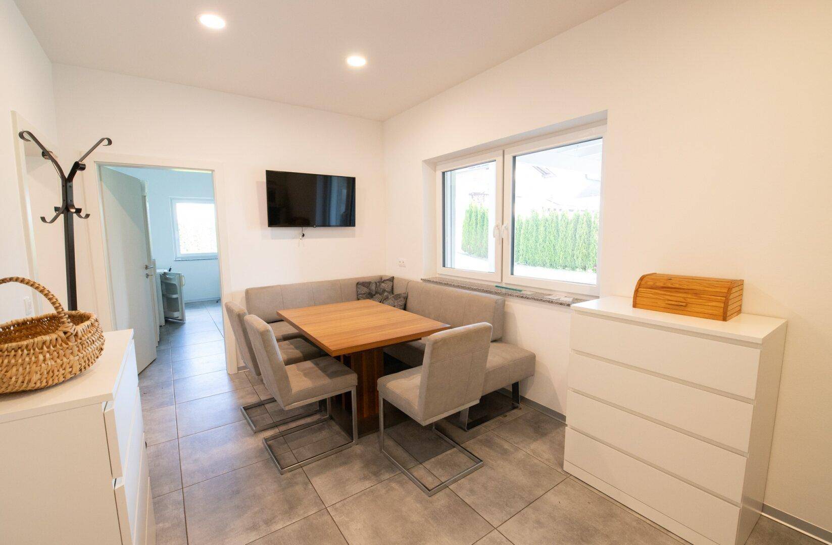 Gemütlicher Essbereich mit Eckbank und Holztisch, angrenzend an eine moderne Küche.