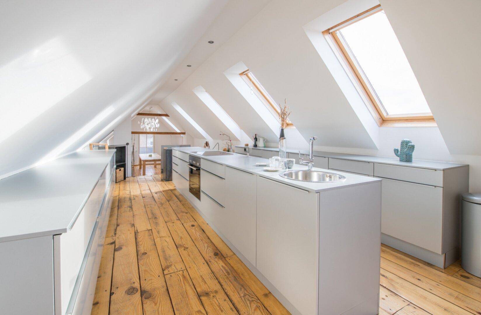 Weitläufige moderne Dachgeschossküche mit mehreren Oberlichtern und offenem Grundriss.