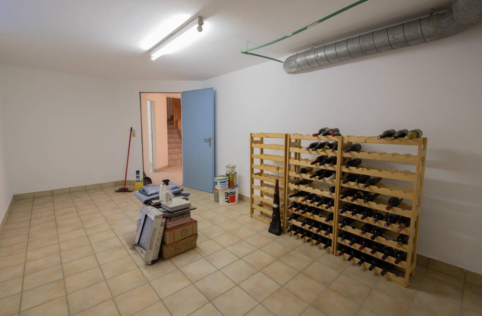 Kellerraum mit Fliesenboden und Weinregalen, perfekt für die Lagerung von Weinflaschen.