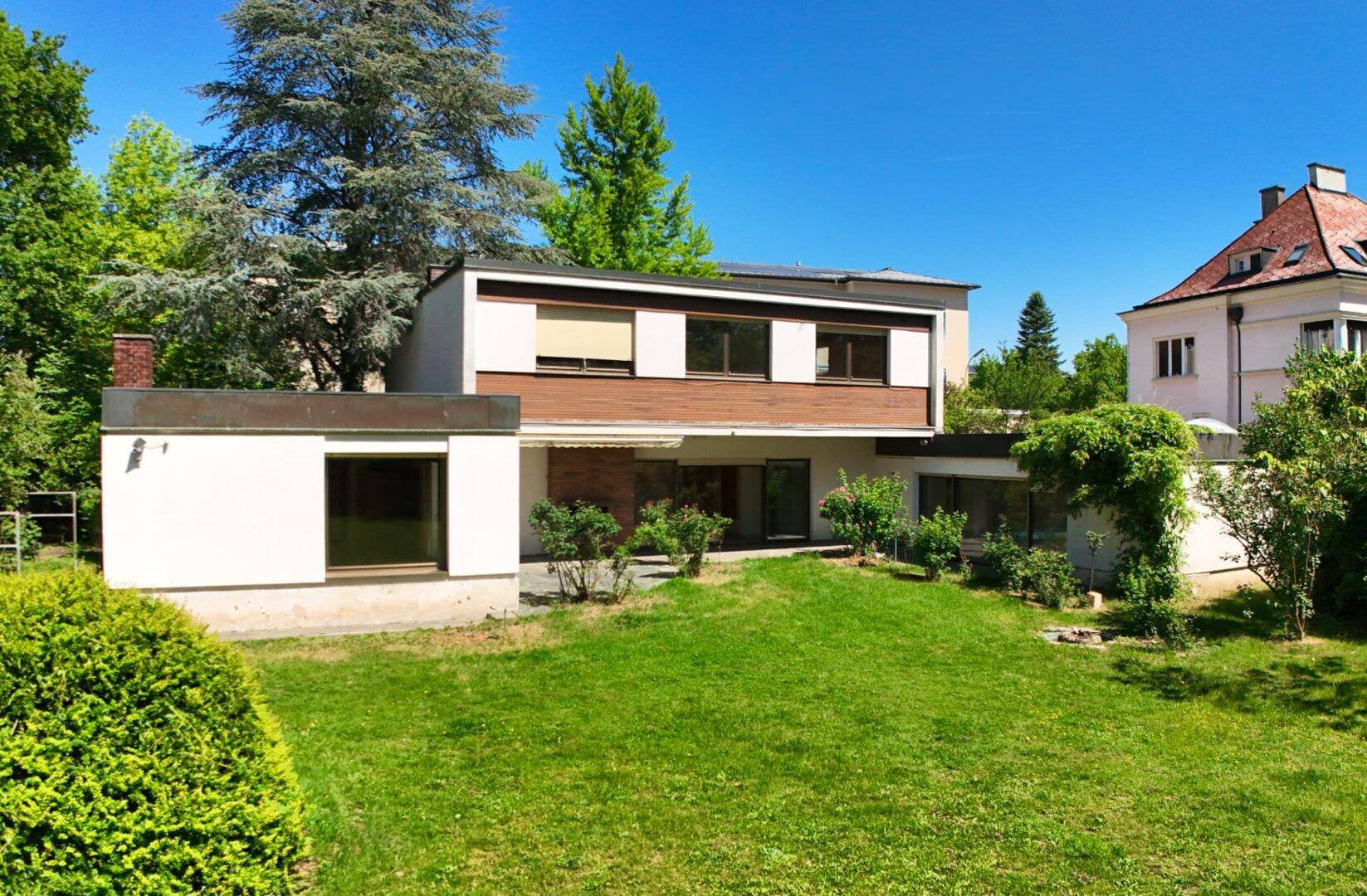 Ansicht des modernen Hauses mit weitläufigem Garten und gepflegter Rasenfläche.