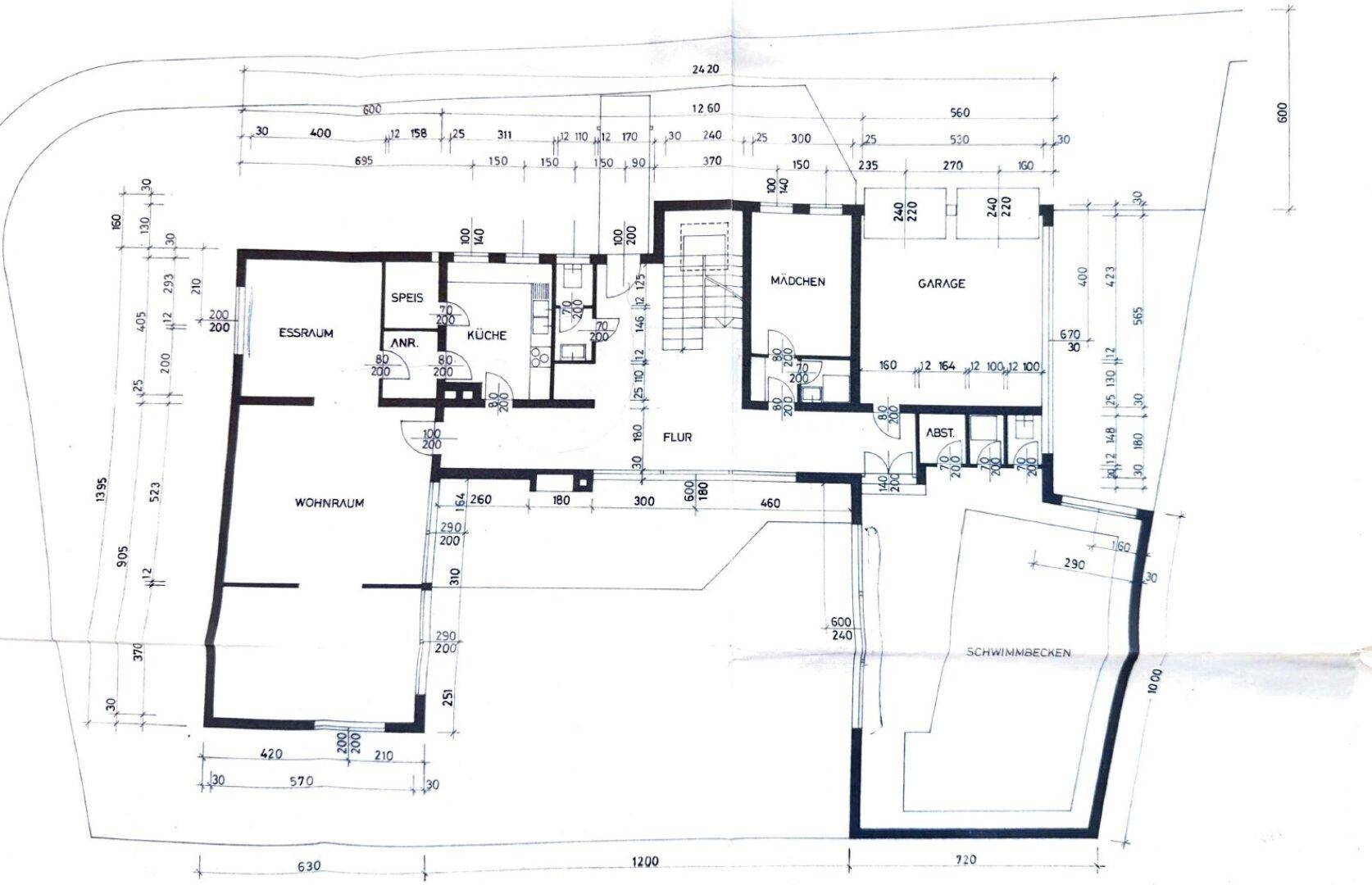 Grundriss des Erdgeschosses mit Wohnzimmer, Essbereich, Küche, Garage und Schwimmbecken.