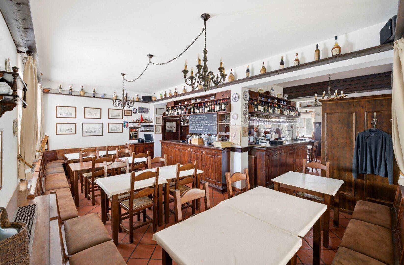 Gemütlicher Essbereich mit Bar, dunklen Holzmöbeln, Terrakotta-Fliesen und traditioneller Dekoration.