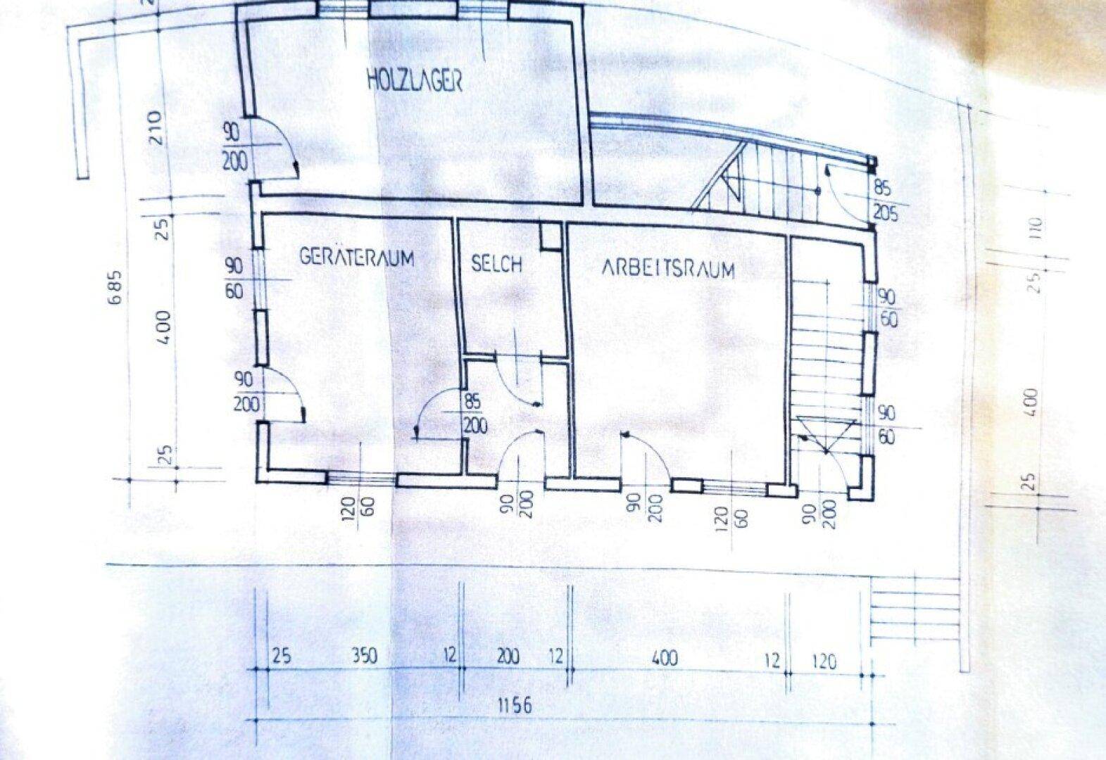 Grundriss des Untergeschosses mit Holz-, Geräte- und Arbeitsräumen sowie einem Treppenaufgang.