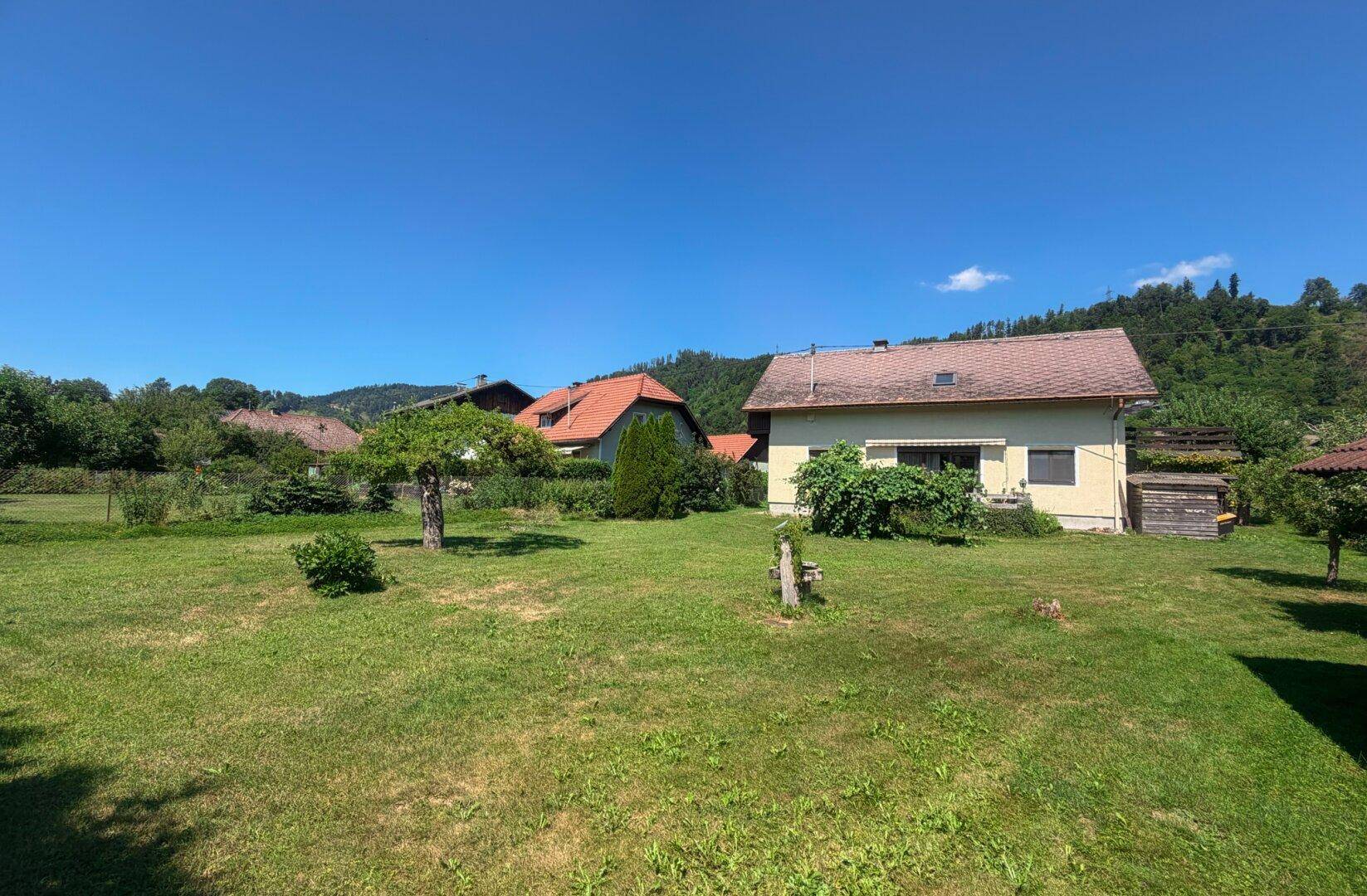 Großer, gepflegter Gartenbereich mit Rasen und Blick auf das Haus und die Umgebung.