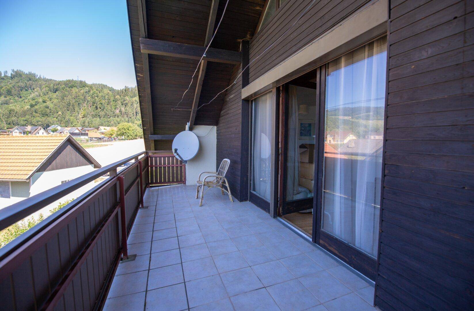 Geräumiger Balkon mit Fliesenboden und weitem Blick auf die umliegende Landschaft.