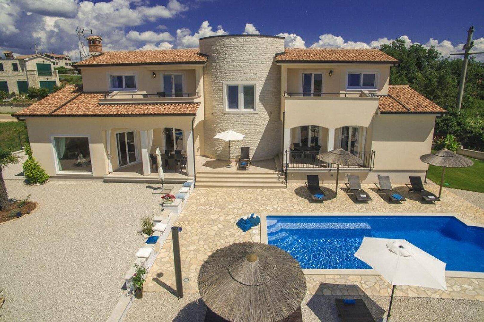 Vogelperspektive der Villa mit großem Swimmingpool, Sonnenterrasse und mediterraner Bepflanzung.
