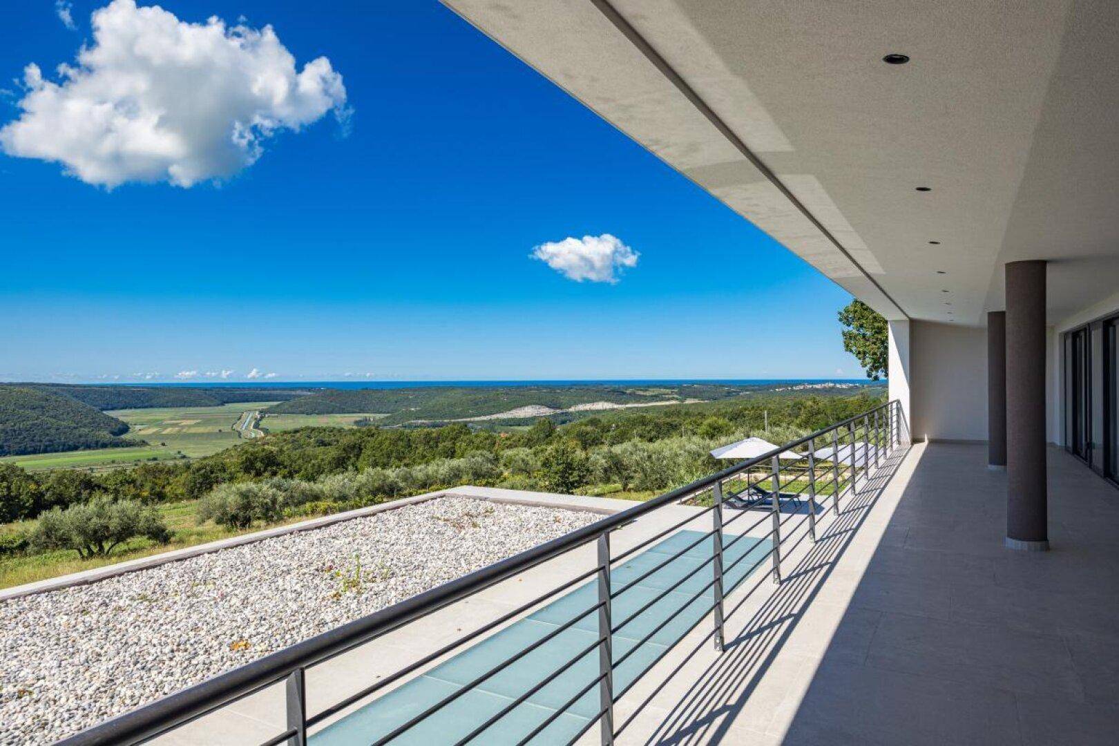 Geräumiger Balkon mit Panoramablick über die weite Landschaft und das Meer.