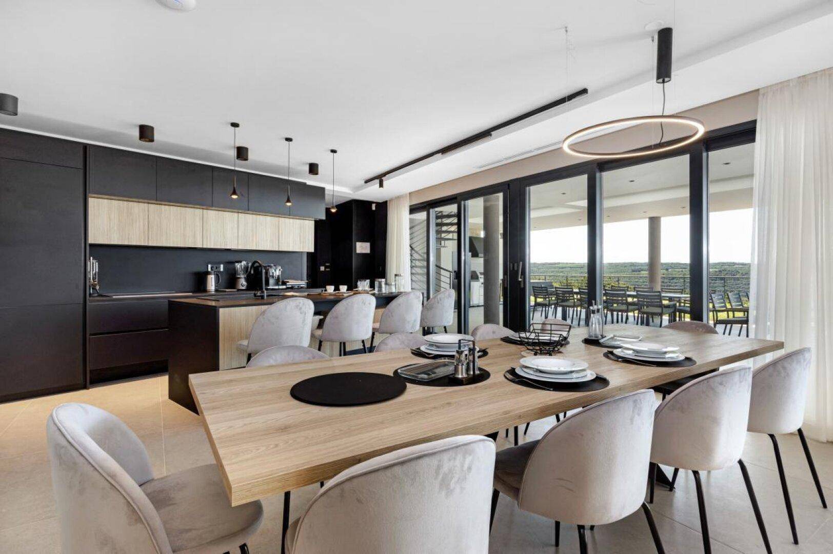 Offener Essbereich mit Holztisch, modernen Stühlen und integrierter Küche mit Blick.