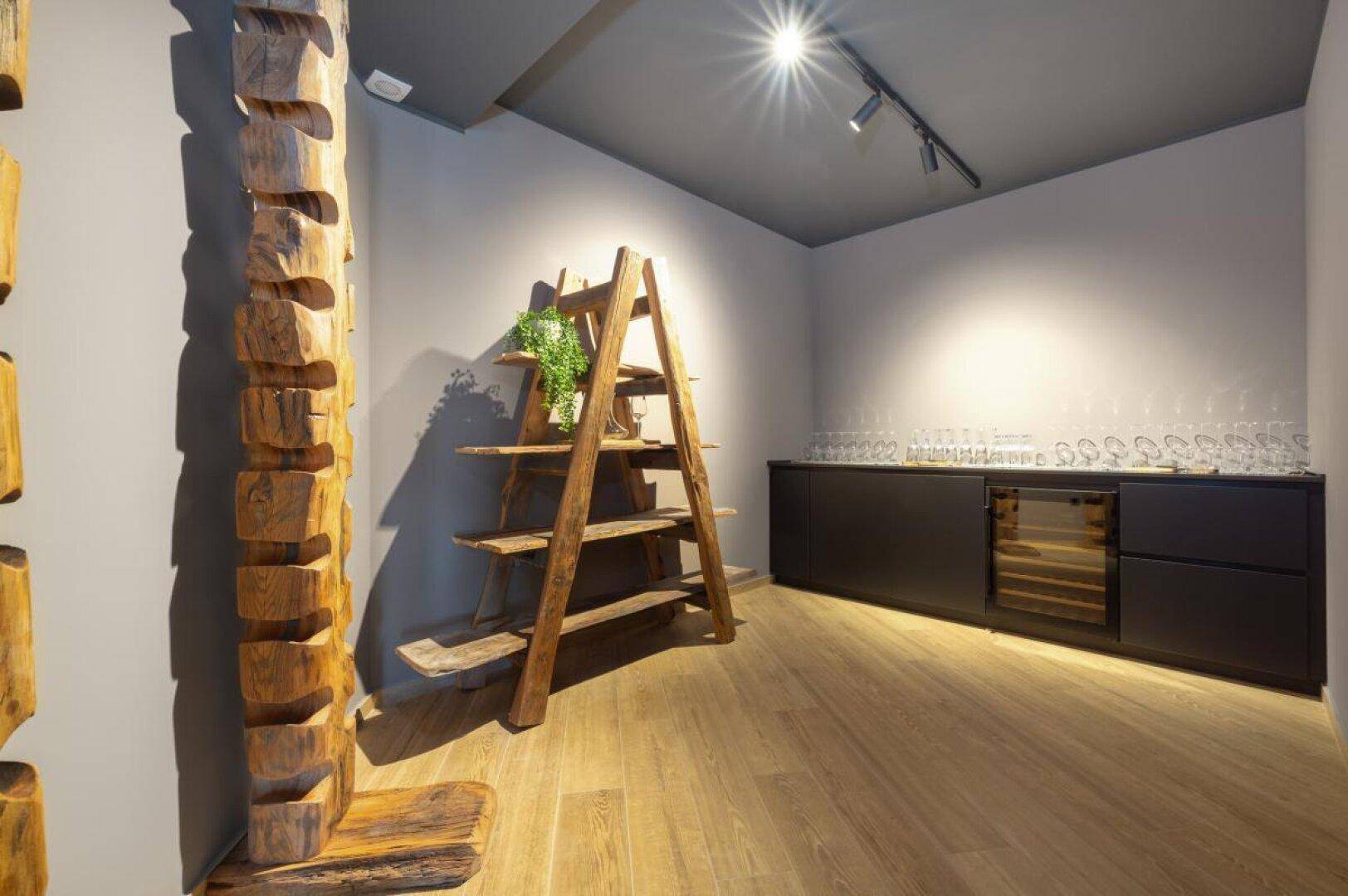 Kleiner Raum mit Holzregalen, Weinkühler und indirekter Beleuchtung.