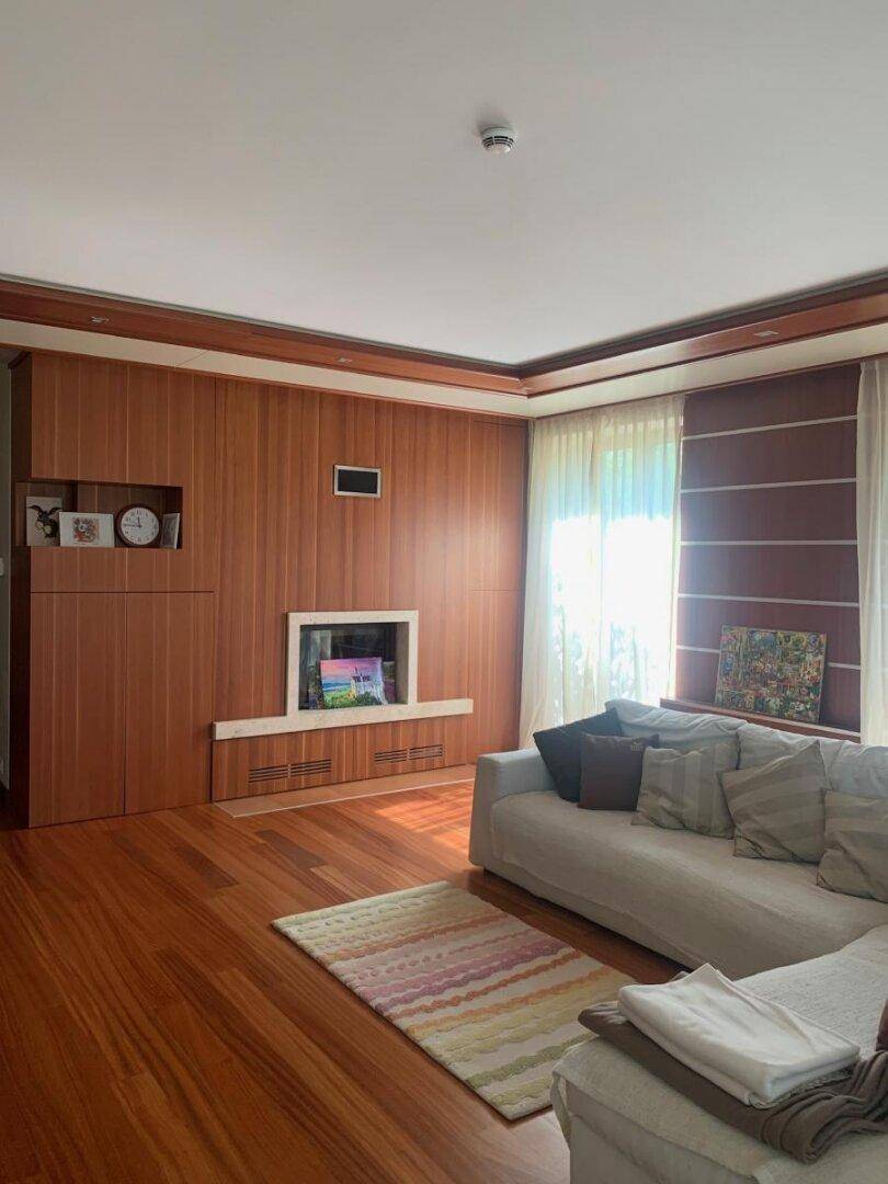 Gemütliches Wohnzimmer mit Holzwänden, integriertem Kamin und bequemer Eckcouch.
