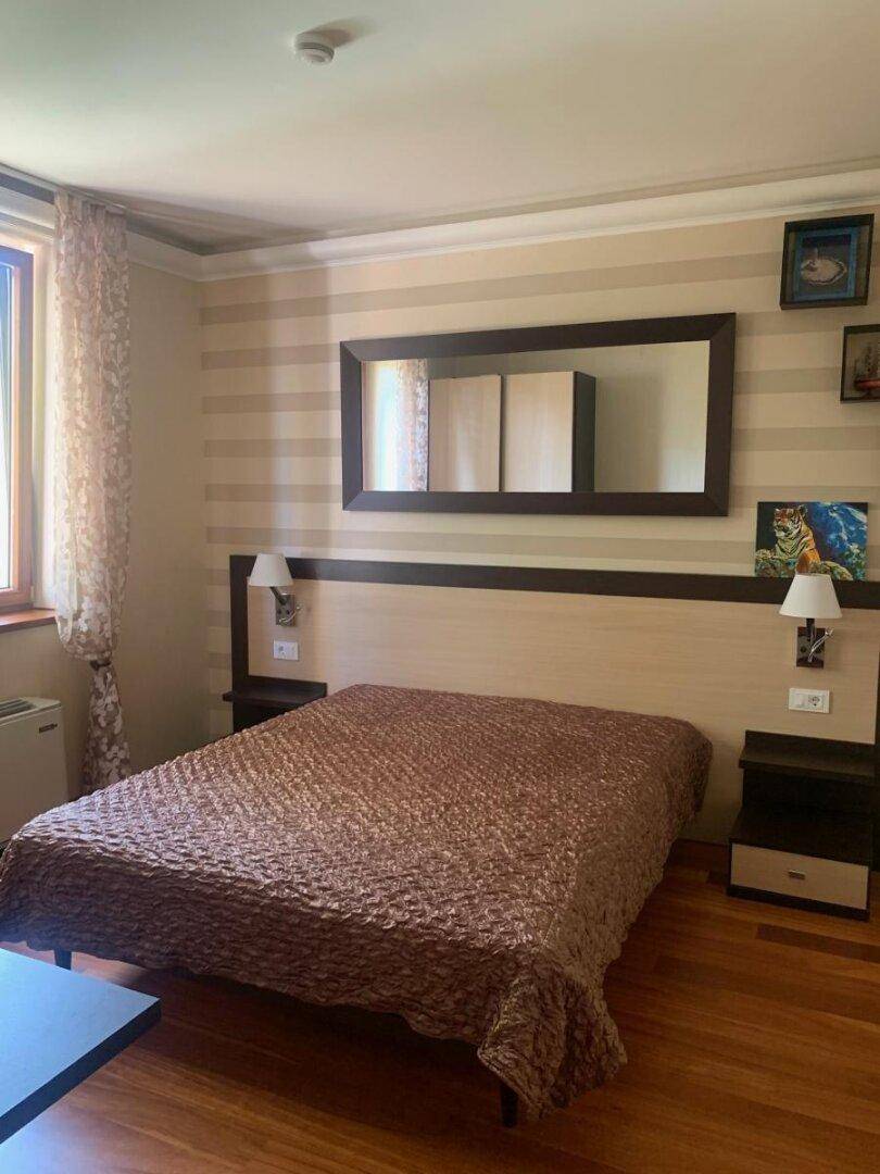 Gemütliches Schlafzimmer mit Doppelbett, Holzboden und gestreiften Wänden.