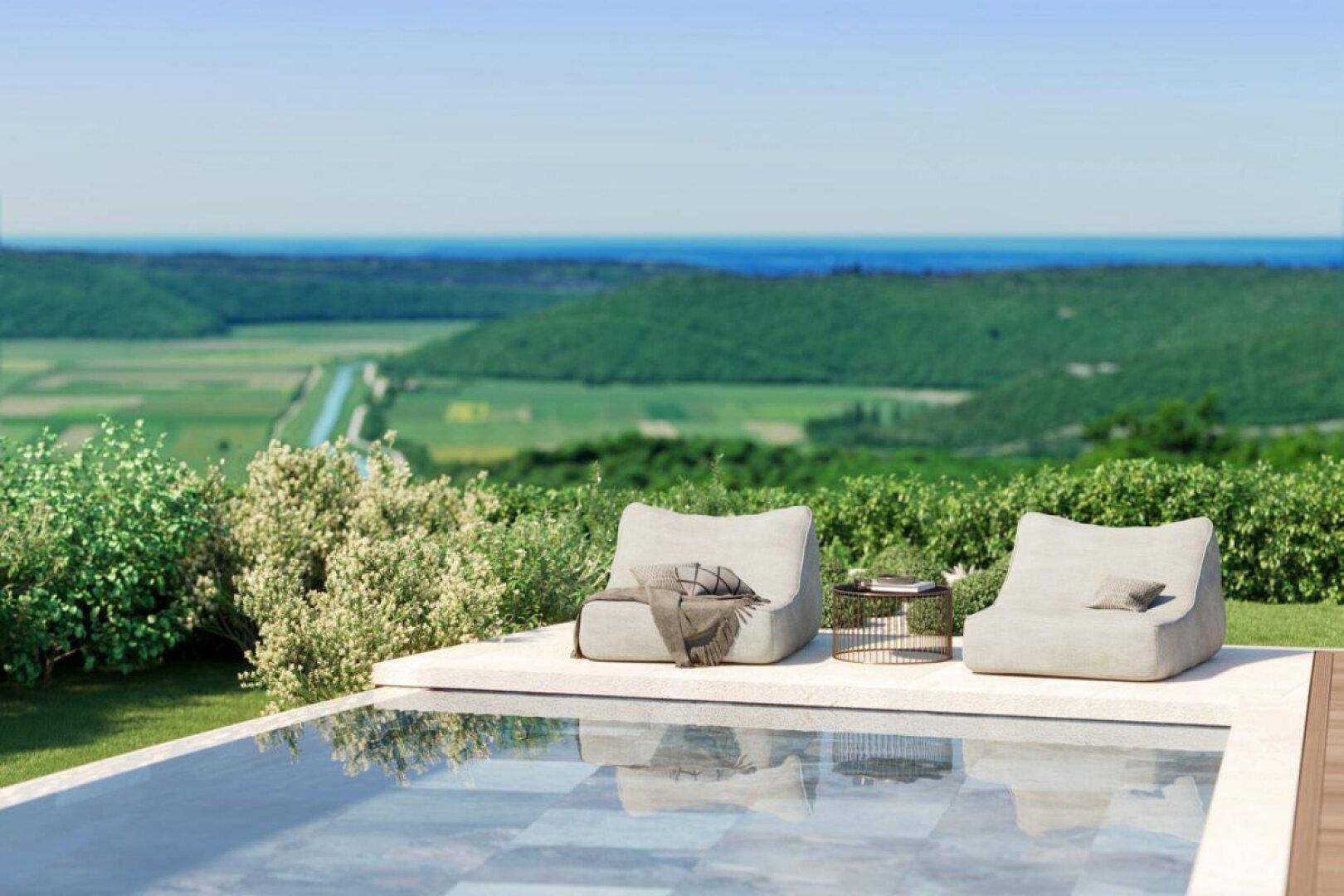 Entspannungsbereich am Pool mit bequemen Sitzsäcken und weitem Blick auf das Meer und die grüne Landschaft.