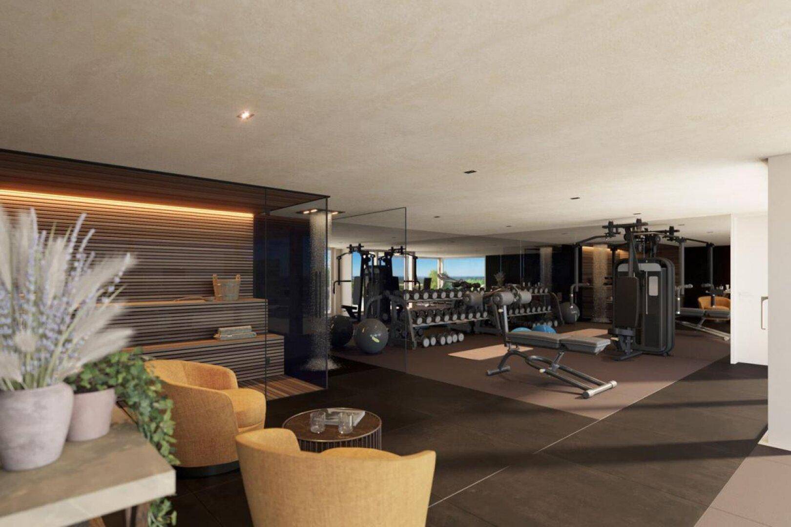 Moderner Fitnessraum mit verschiedenen Trainingsgeräten und einem Entspannungsbereich mit bequemen Sesseln.