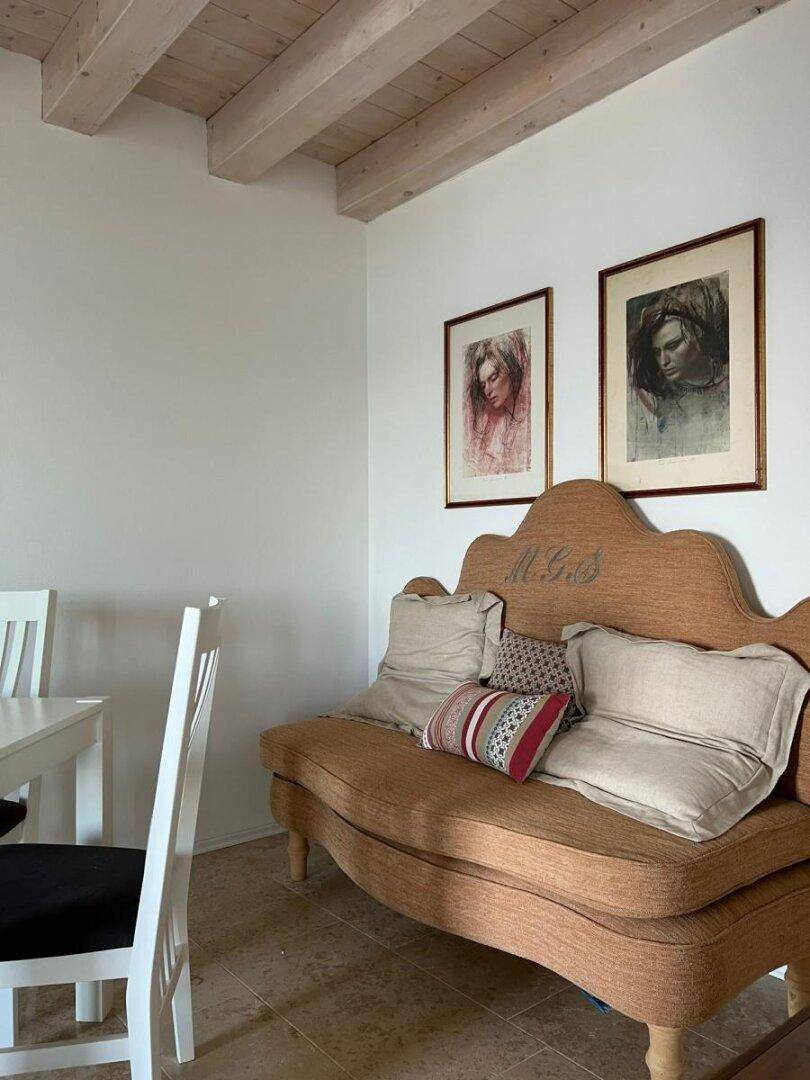 Wohnbereich mit rustikaler Sitzbank und Holzbalkendecke, kombiniert mit modernem Esstisch.