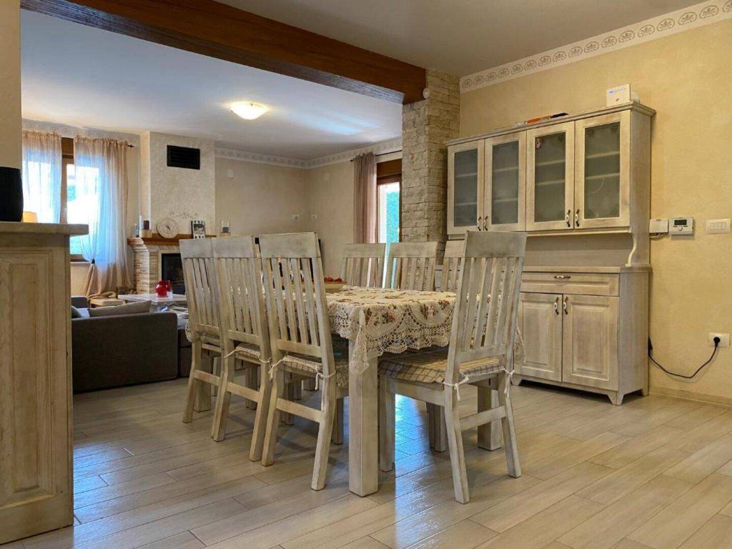 Geräumiger Wohn- und Essbereich mit großem Esstisch, Sideboard und Blick auf den Kamin.