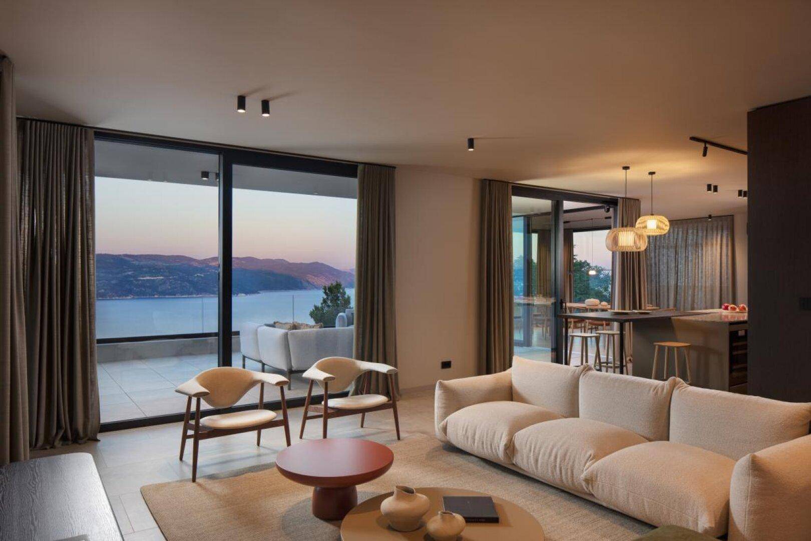 Gemütliches Wohnzimmer mit großen Fenstern, die einen malerischen Blick auf das Meer bieten.