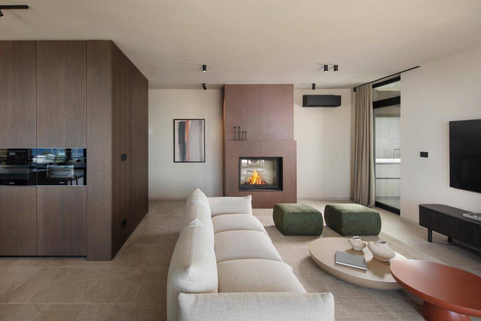 Stilvolles Wohnzimmer mit modernem Kamin, bequemen Sofas und integrierten Schränken.