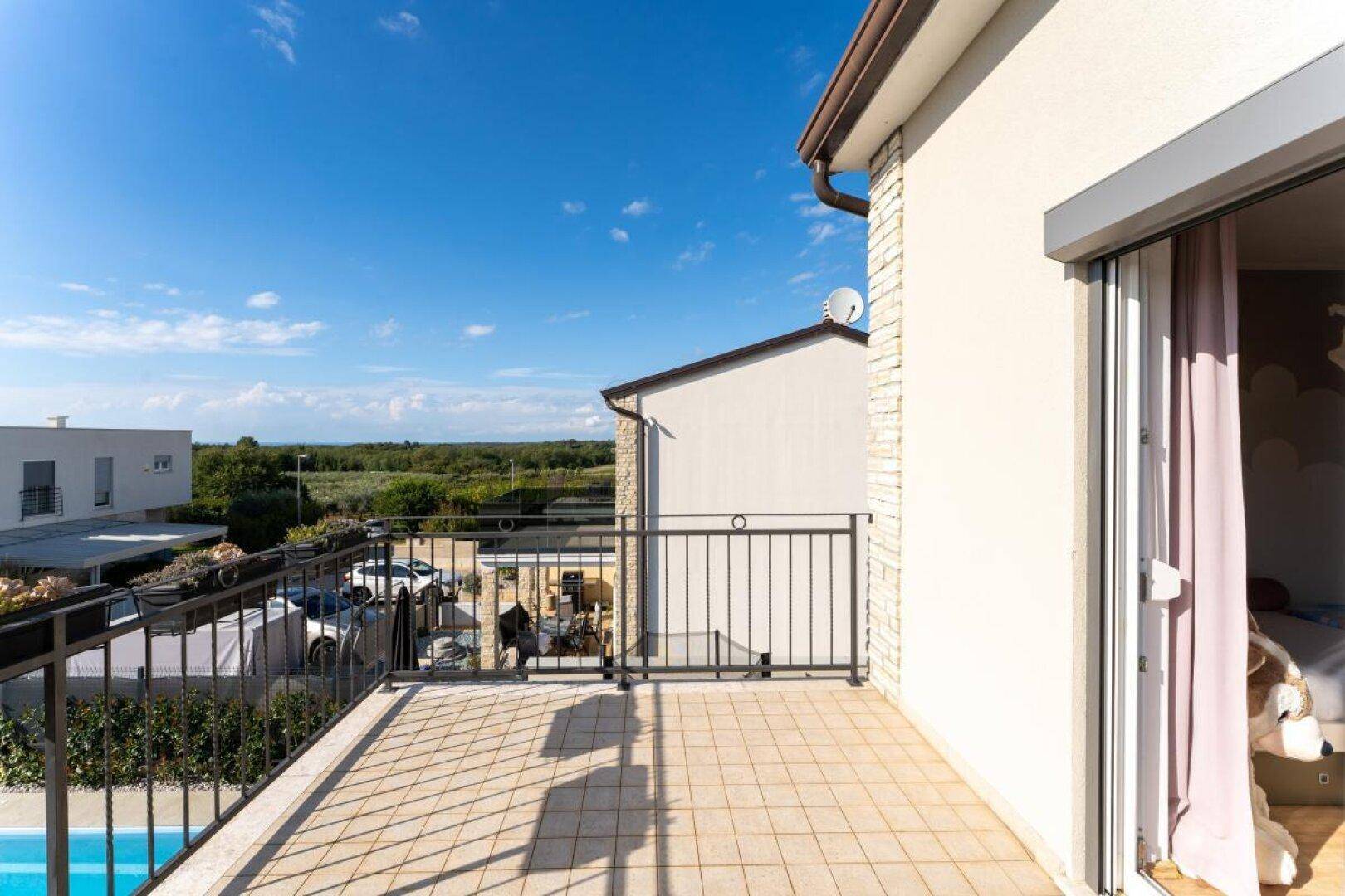 Balkon mit Fliesenboden und Blick auf die Umgebung und den privaten Pool.