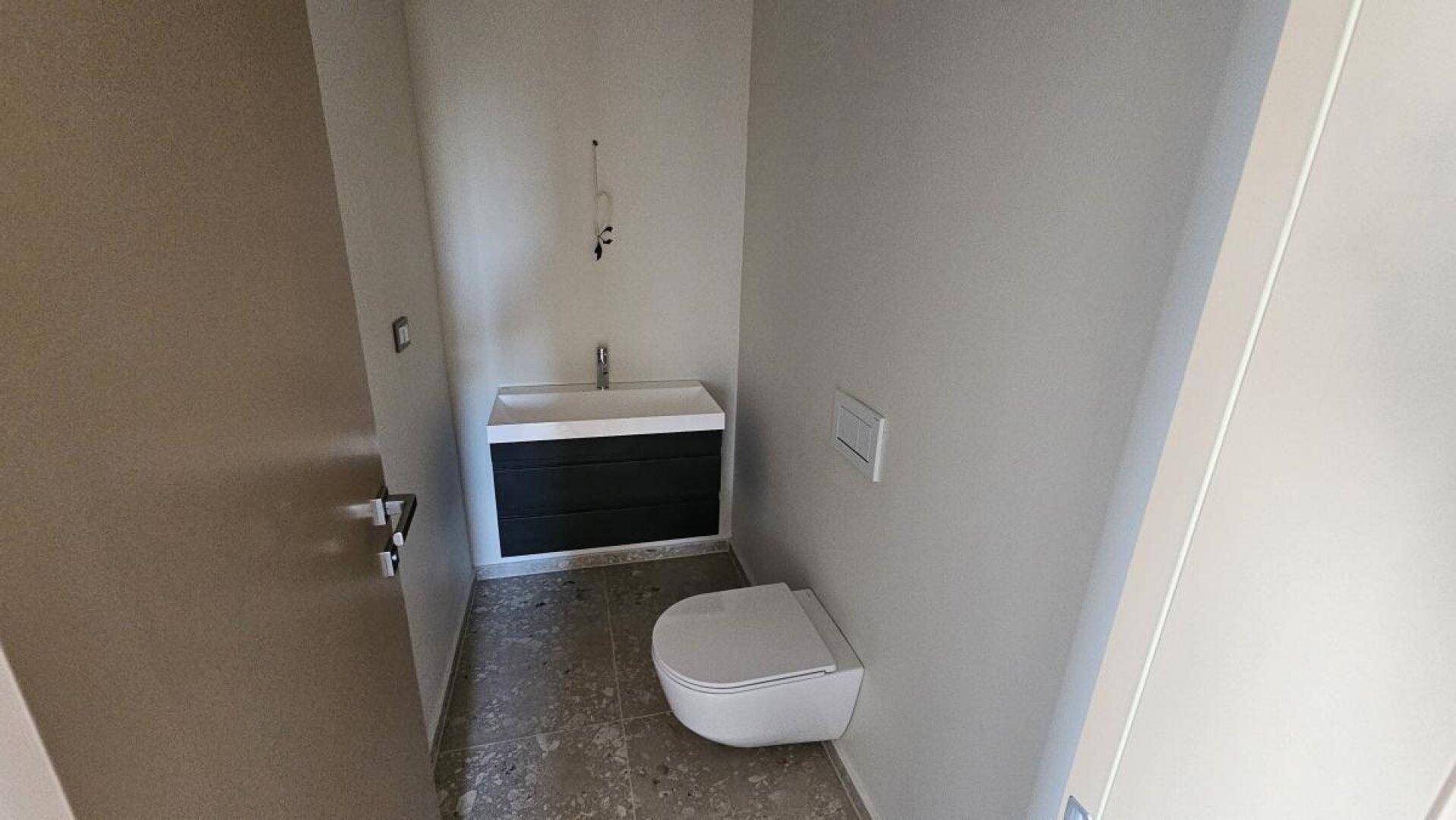 Modernes Gäste-WC mit schwebendem Waschtisch und wandhängender Toilette.