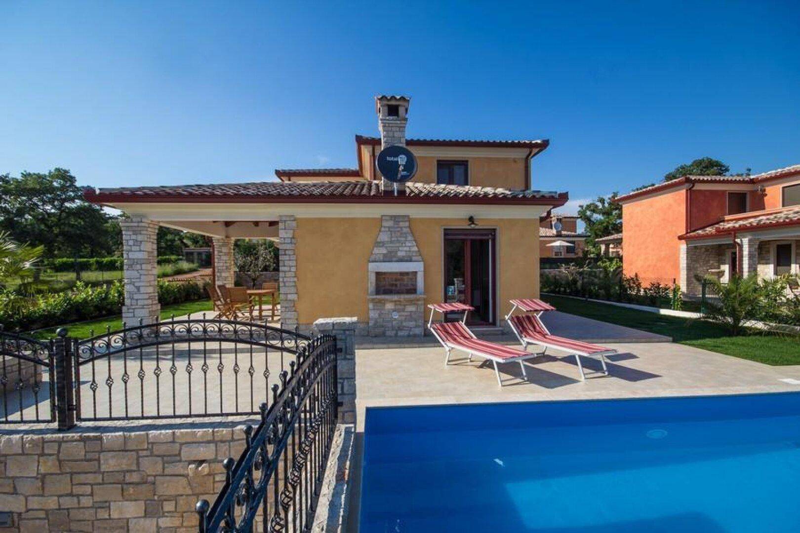 Poolbereich mit Sonnenliegen und überdachter Terrasse, ideal für entspannte Stunden im Freien.